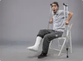 front-view-young-male-with-broken-foot-trying-stand-up-holding-crutches-grey-wall-foot-broken-pain-twist-accident-leg